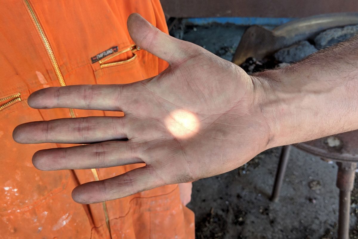 A dot of light is caught on the palm of an open hand