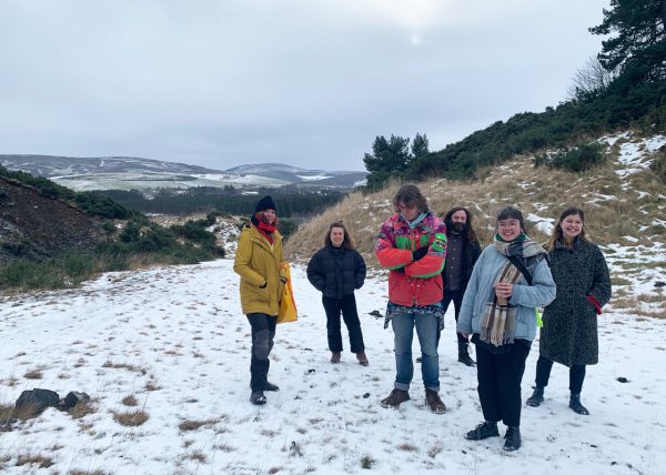 A group of people stand in a snowy landscape