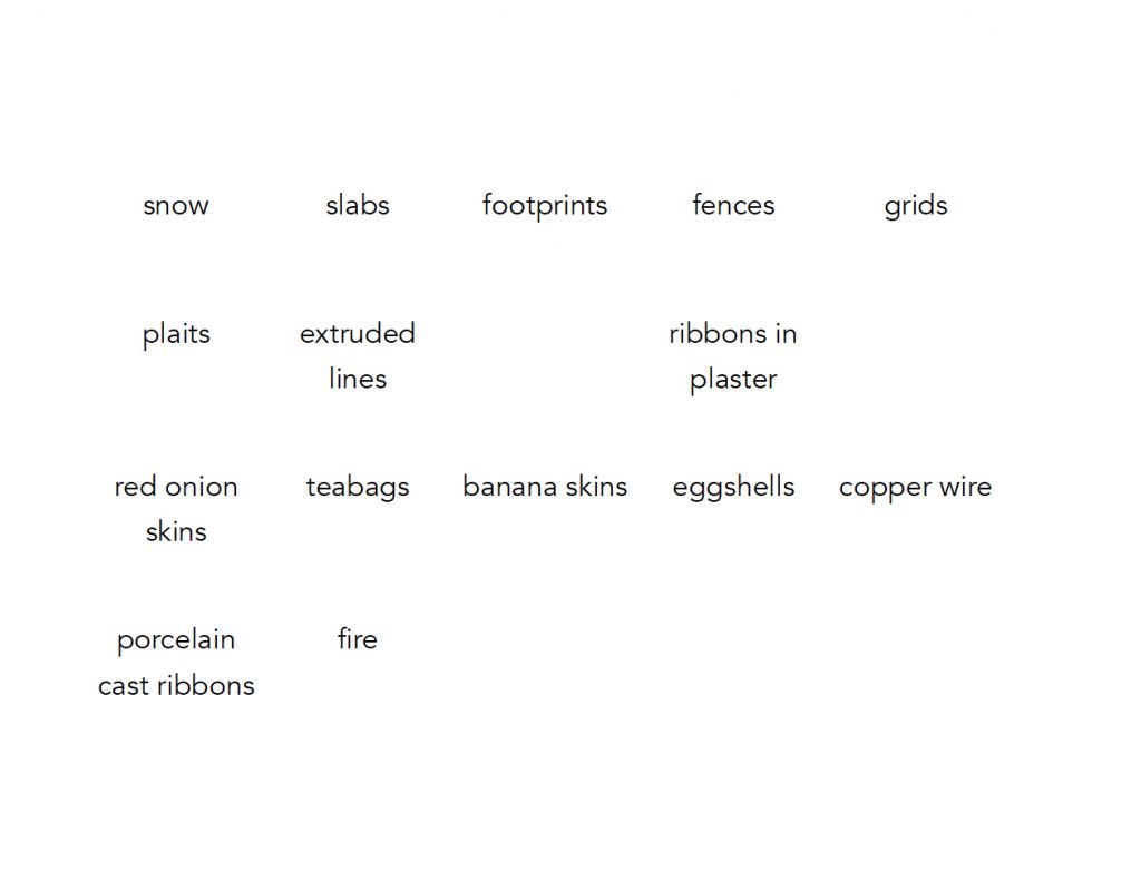 Words in black font, laid out in a grid on a white background. The words read: snow, slabs, footprints, fences, grids, plaits, extruded lines, ribbons in plaster, red onion skins, teabags, banana skins, eggshells, copper wire, porcelain cast ribbons, fire